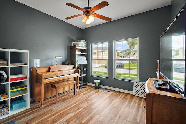 sitting room with ceiling fan, wood finished floors, and baseboards