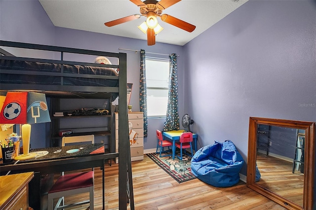 bedroom featuring wood finished floors, a ceiling fan, and baseboards