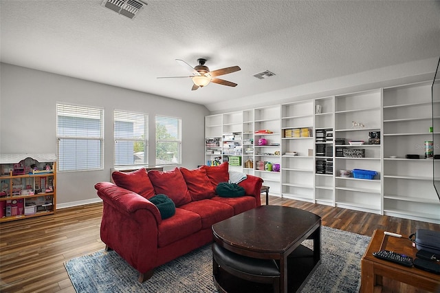 living area featuring visible vents, wood finished floors, ceiling fan, and a textured ceiling