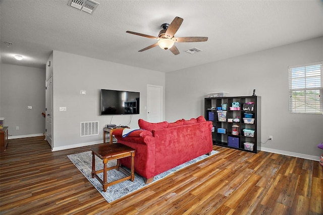 living room featuring a ceiling fan, visible vents, and wood finished floors