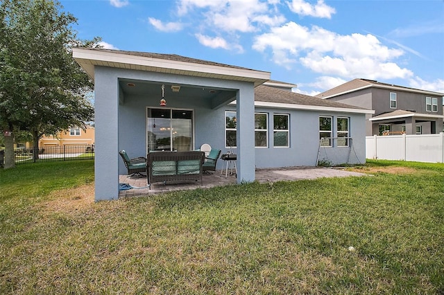 back of property featuring a patio, a yard, and stucco siding
