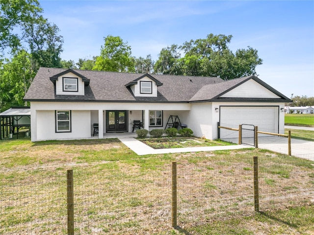 view of front of house featuring french doors, stucco siding, a front yard, and an attached garage