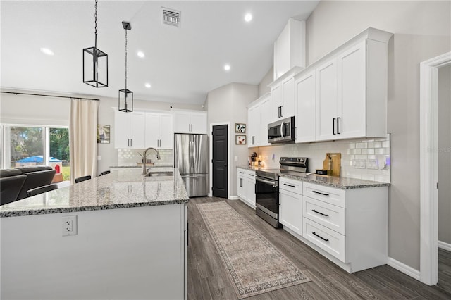 kitchen featuring dark wood-style floors, a sink, stainless steel appliances, a center island with sink, and visible vents