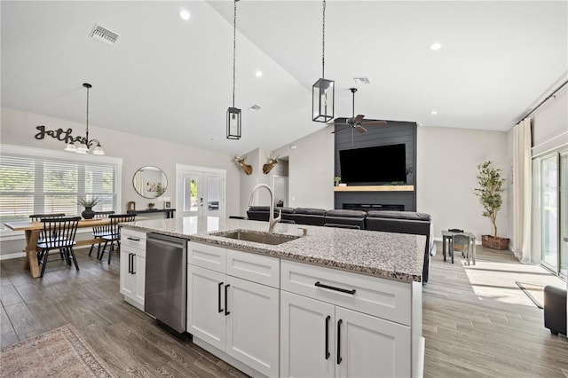 kitchen with ceiling fan, dishwasher, a sink, pendant lighting, and lofted ceiling