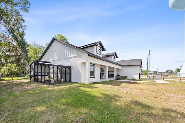 view of side of home featuring a lawn and fence