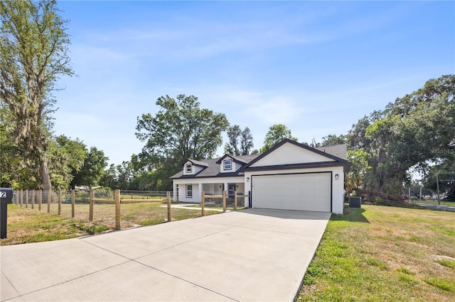 view of front of house with driveway, fence, a front yard, and an attached garage