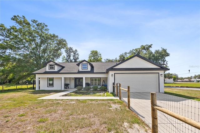view of front of home featuring fence, concrete driveway, a front lawn, and a garage