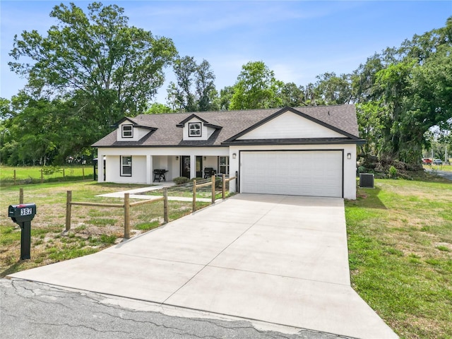 view of front of home featuring roof with shingles, a front yard, concrete driveway, and an attached garage