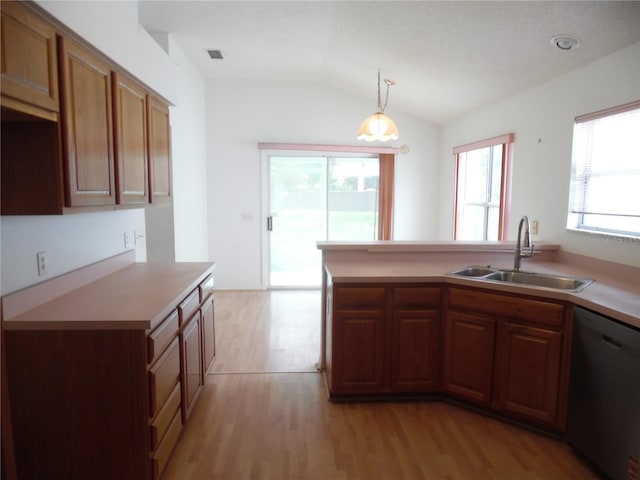 739 Cortez Ave, The Villages, FL 32159 - kitchen with dishwashing machine, light wood finished floors, vaulted ceiling, light countertops, and brown cabinets