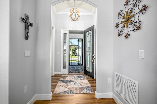 8492 Hartford Way, Mount Dora, FL 32757 - foyer featuring wood finished floors, crown molding, a chandelier, and arched walkways