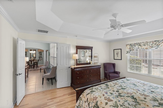 1140 Eureka Mill Run, The Villages, FL 32162 - bedroom featuring crown molding, a raised ceiling, light wood finished floors, and multiple windows