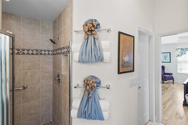 1140 Eureka Mill Run, The Villages, FL 32162 - bathroom with a stall shower, baseboards, and wood finished floors