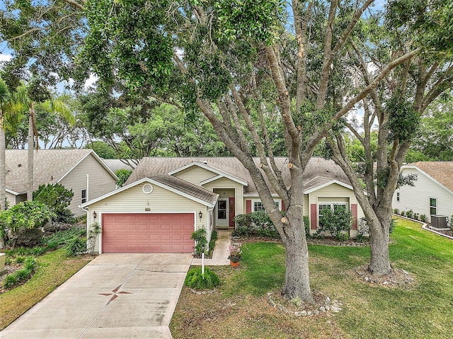 view of front facade featuring concrete driveway, central air condition unit, a front lawn, and a garage