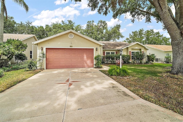 single story home with a garage, a front yard, and concrete driveway