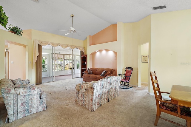 living area with carpet flooring, ceiling fan, high vaulted ceiling, visible vents, and arched walkways