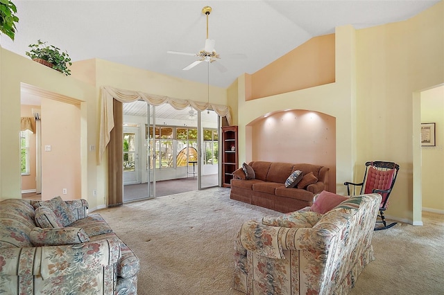 carpeted living area with baseboards, high vaulted ceiling, arched walkways, and ceiling fan