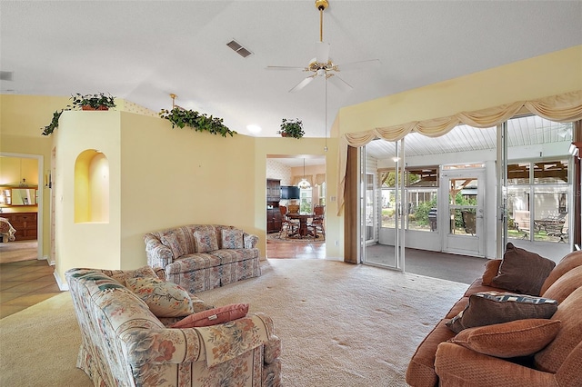living area with visible vents, a ceiling fan, vaulted ceiling, and carpet floors