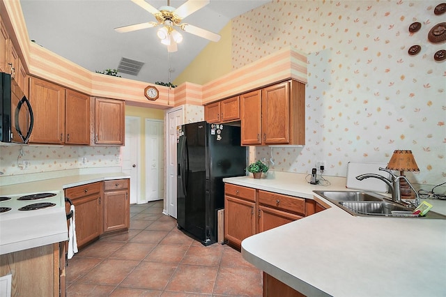 kitchen featuring wallpapered walls, vaulted ceiling, black appliances, a sink, and visible vents