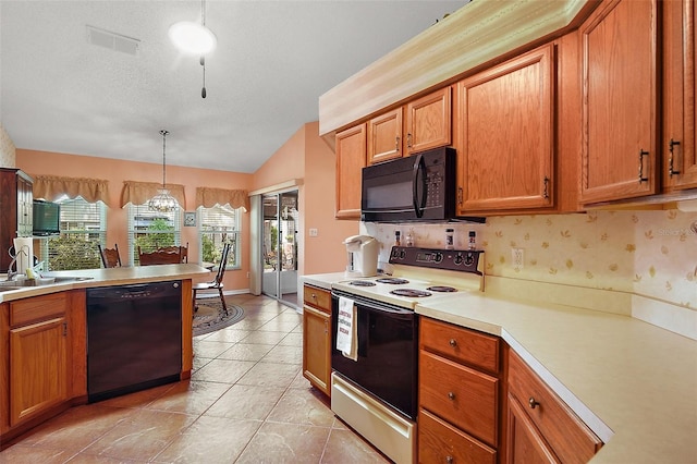 kitchen with visible vents, black appliances, brown cabinetry, and light countertops