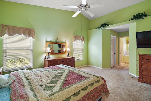 bedroom featuring lofted ceiling, light colored carpet, ceiling fan, ensuite bathroom, and baseboards