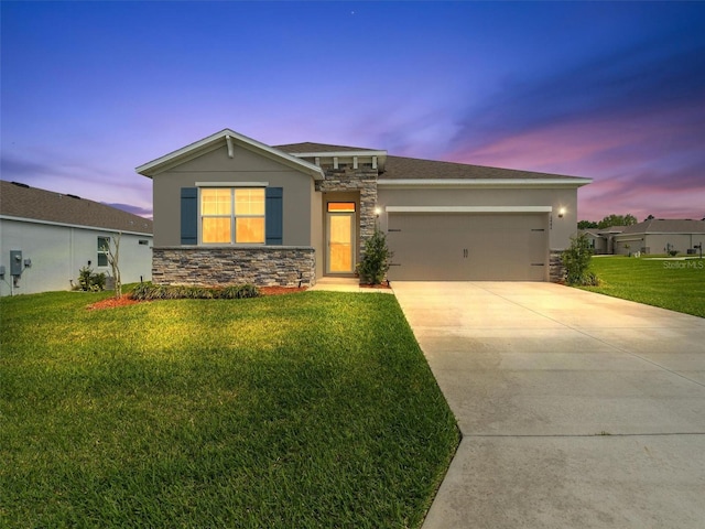 view of front facade featuring a front yard, stone siding, stucco siding, and a garage