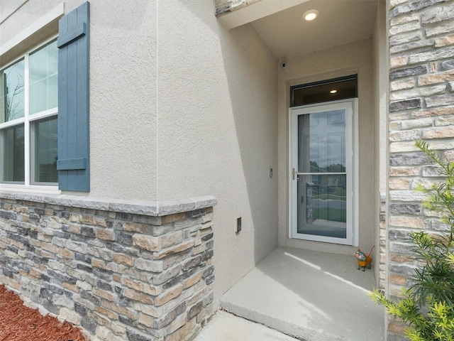 entrance to property with stucco siding and stone siding