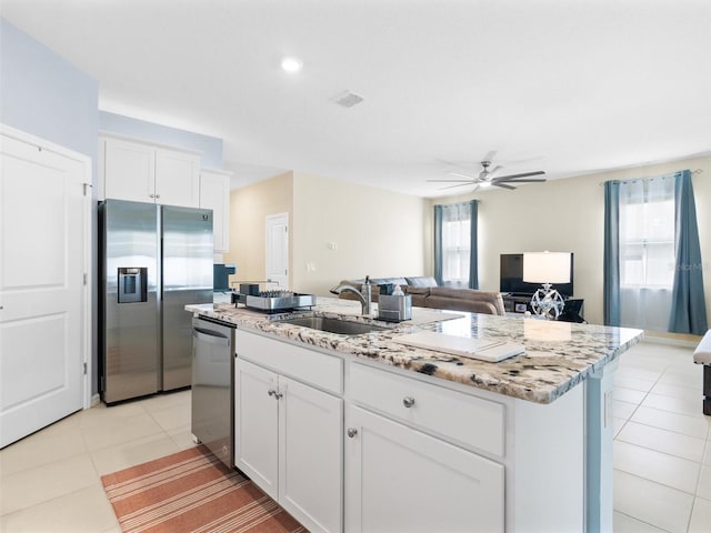 kitchen featuring light tile patterned floors, a sink, stainless steel appliances, a kitchen island with sink, and a ceiling fan