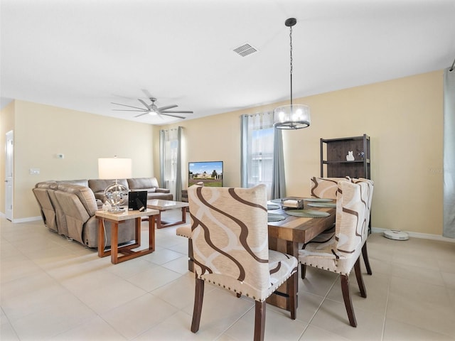 dining area featuring baseboards, visible vents, ceiling fan with notable chandelier, and light tile patterned flooring