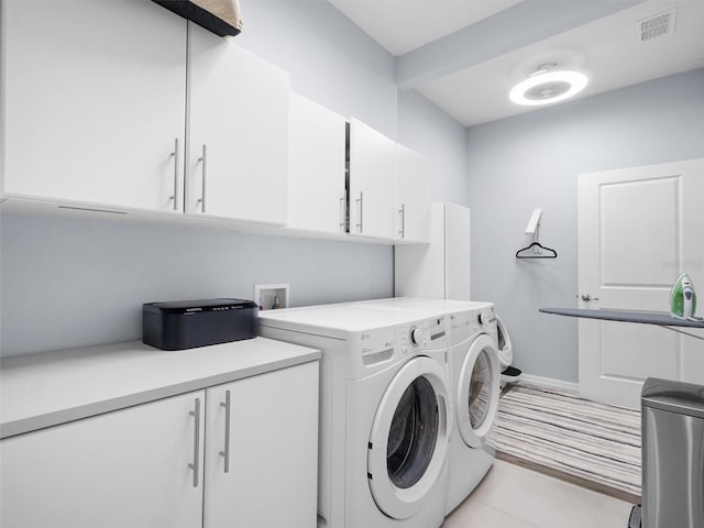 laundry room with washing machine and clothes dryer, visible vents, baseboards, light tile patterned flooring, and cabinet space