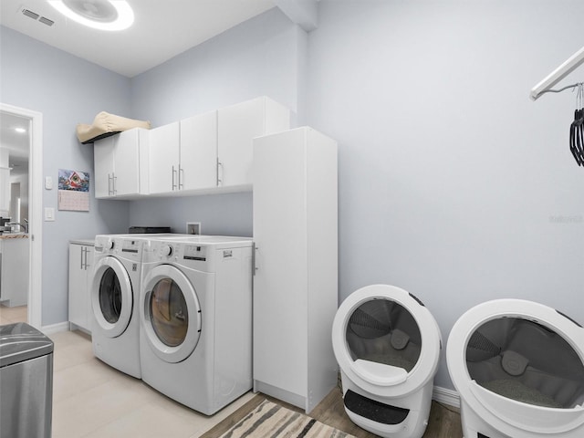 laundry room featuring visible vents, cabinet space, and washing machine and dryer