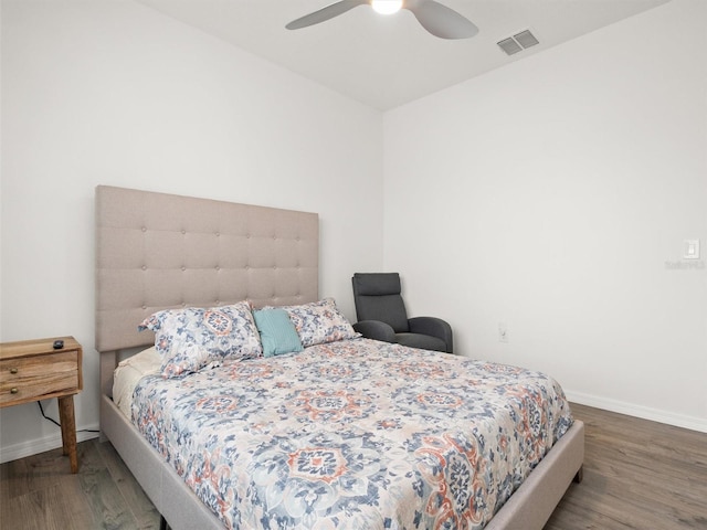 bedroom featuring visible vents, ceiling fan, wood finished floors, and baseboards
