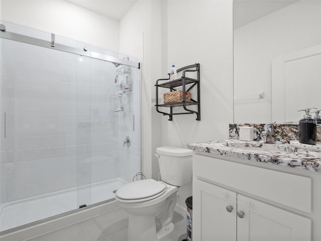 bathroom featuring toilet, a stall shower, and vanity