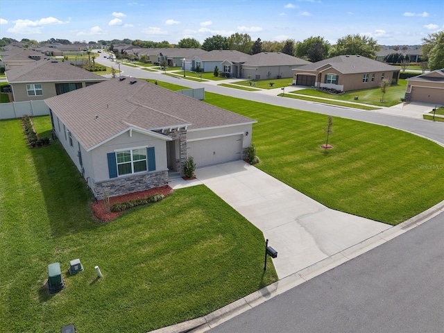 view of front of property with concrete driveway, a residential view, stone siding, an attached garage, and stucco siding
