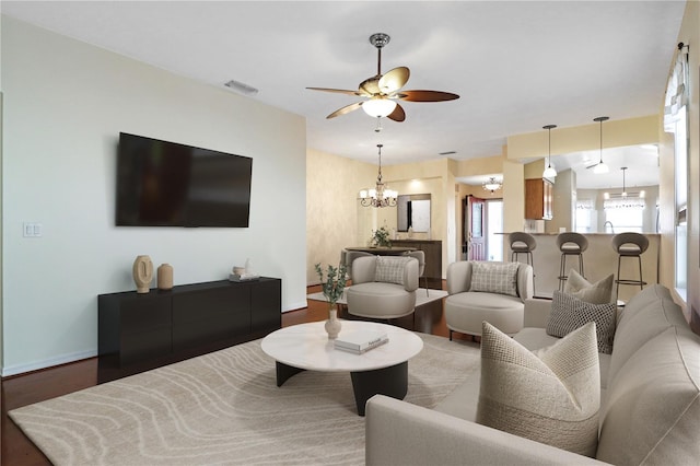 4848 Saint Andrews Arc, Leesburg, FL 34748 - living room featuring wood finished floors, visible vents, baseboards, and ceiling fan with notable chandelier
