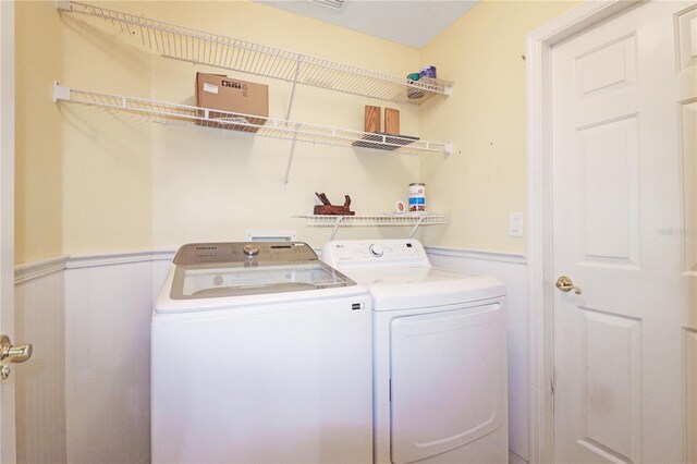 4848 Saint Andrews Arc, Leesburg, FL 34748 - laundry room featuring wainscoting, separate washer and dryer, and laundry area