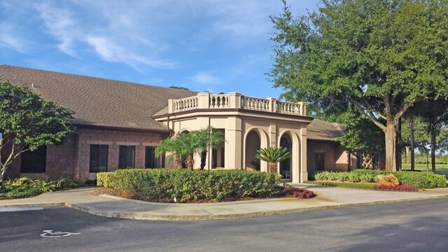 4848 Saint Andrews Arc, Leesburg, FL 34748 - view of front facade featuring uncovered parking, stucco siding, and a balcony