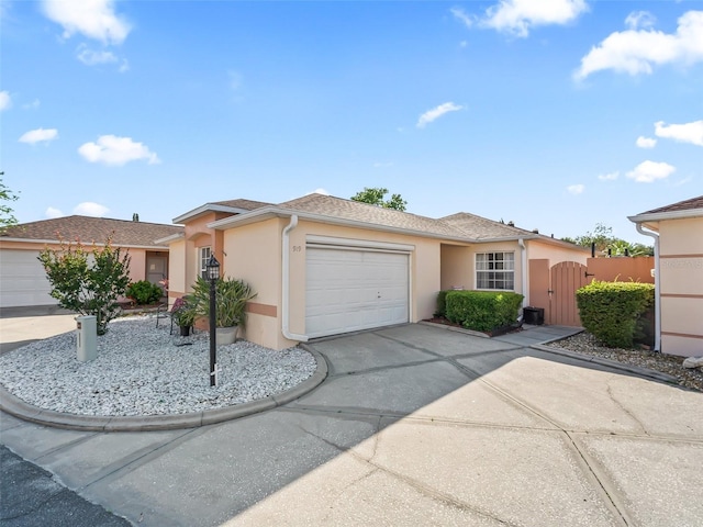 single story home with concrete driveway, a garage, a gate, and stucco siding