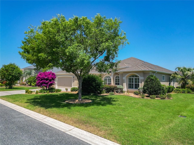 1842 Lake Ridge Dr, The Villages, FL 32162 - view of front of home featuring stucco siding, an attached garage, and a front lawn