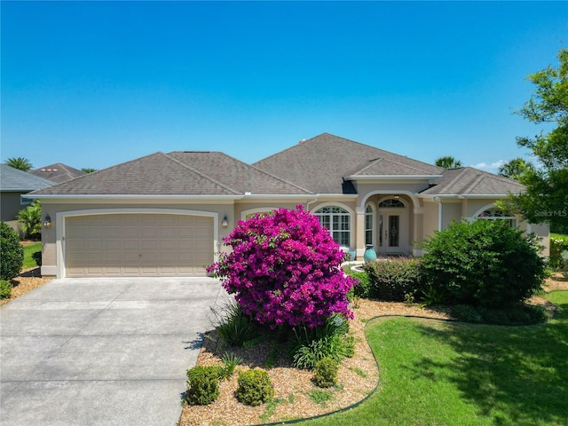 1842 Lake Ridge Dr, The Villages, FL 32162 - ranch-style home featuring an attached garage, stucco siding, driveway, and a front yard