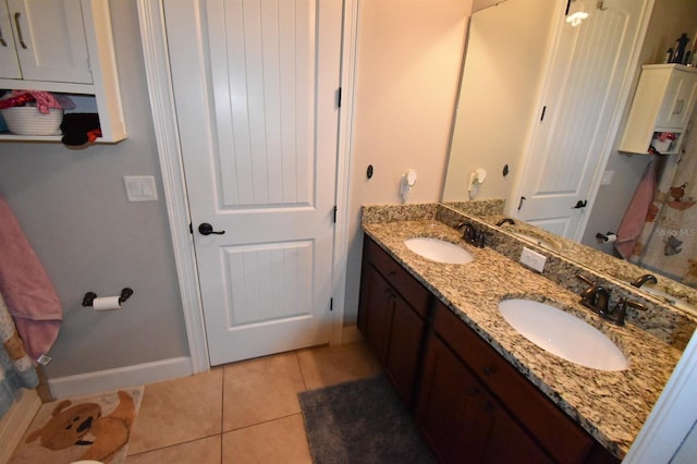 709 Calabria Way, Howey In The Hills, FL 34737 - bathroom featuring tile patterned floors, double vanity, and baseboards