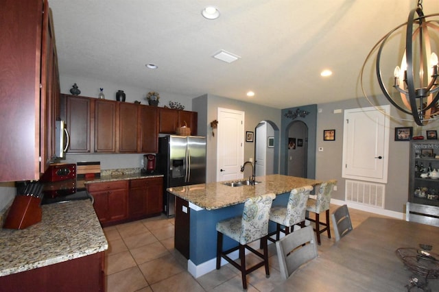 709 Calabria Way, Howey In The Hills, FL 34737 - kitchen featuring stainless steel appliances, a sink, arched walkways, a kitchen bar, and a kitchen island with sink