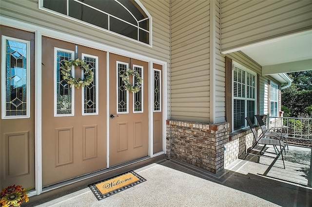 property entrance featuring a porch and stone siding
