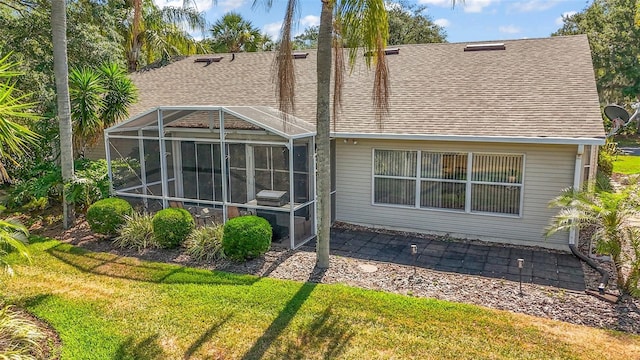rear view of property with a yard, a patio, and a shingled roof