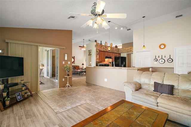 living area with high vaulted ceiling, ceiling fan, rail lighting, and visible vents