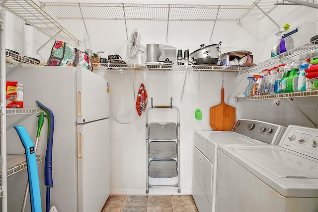clothes washing area with light tile patterned floors, baseboards, laundry area, and washer and dryer
