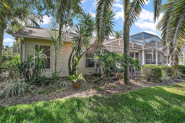 view of home's exterior featuring a lawn and a lanai