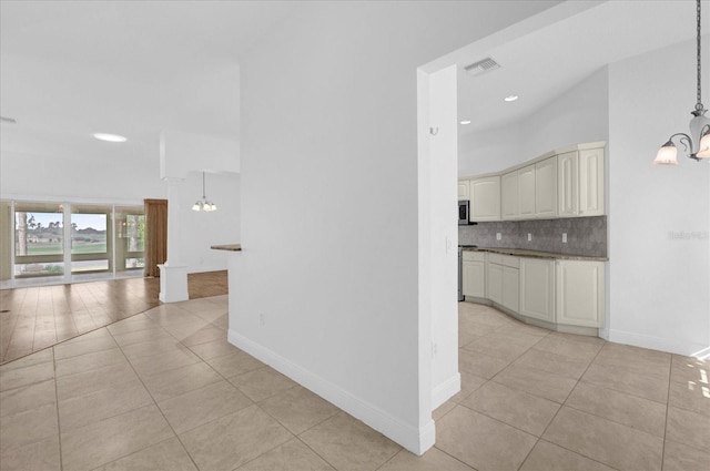 kitchen featuring visible vents, light tile patterned floors, an inviting chandelier, and decorative backsplash