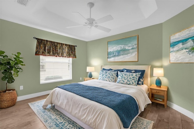 bedroom with visible vents, hardwood / wood-style floors, and baseboards