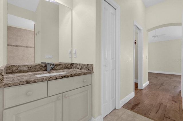 full bath featuring vanity, a closet, ceiling fan, baseboards, and wood finished floors