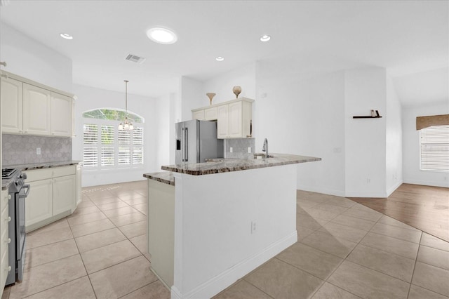 kitchen featuring an inviting chandelier, decorative backsplash, light tile patterned flooring, visible vents, and appliances with stainless steel finishes